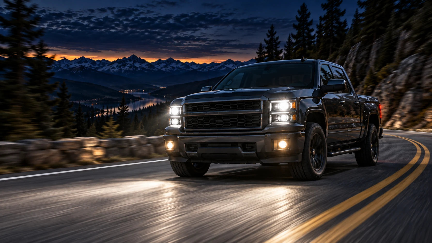A pickup lighting a winding mountain road at dusk